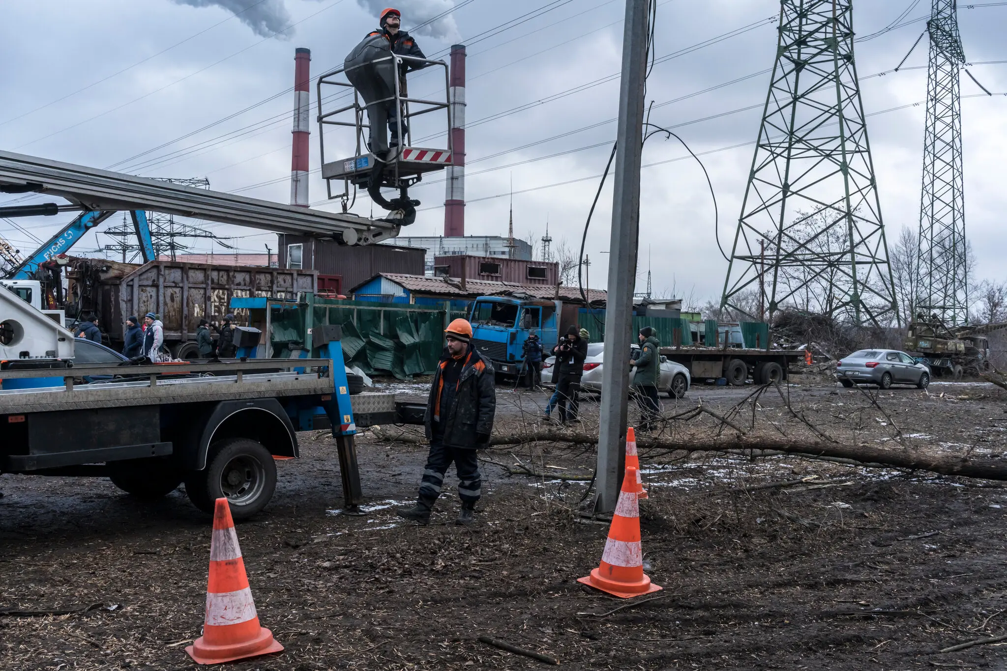 Комунальники ремонтують лінії електропередач після російського ракетного удару неподалік минулого року.